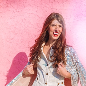 A girl in a sequin jacket on a pink wall