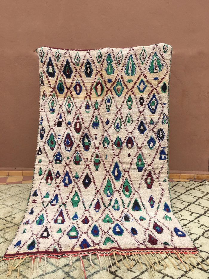 blue and teal patterned rug against wall