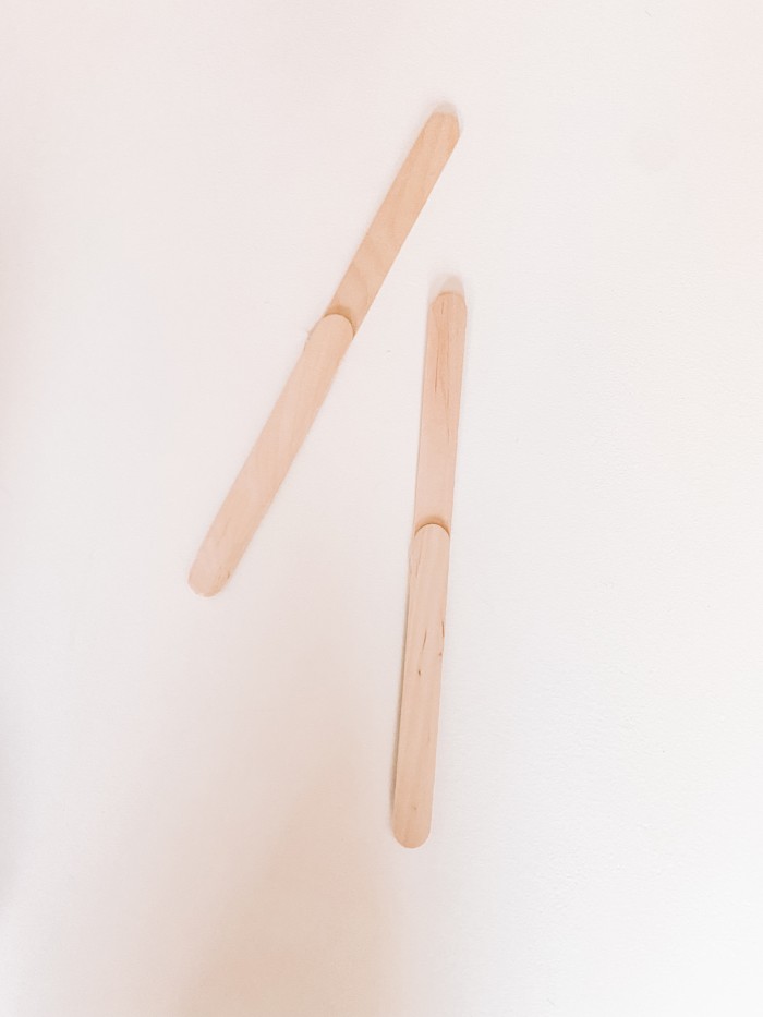 Popsicle sticks glued together on a white table