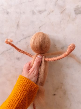 A person holding a doll in the making