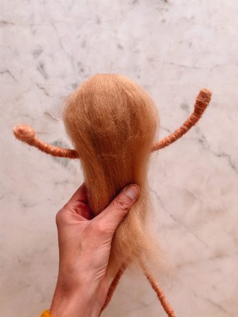 Person holding a doll in the making
