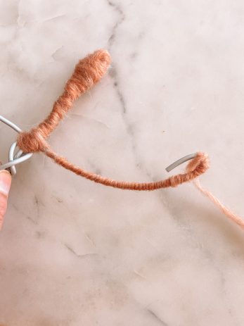 Pink yarn wrapped around a wire