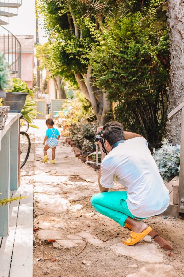 A man taking a photo of a little boy