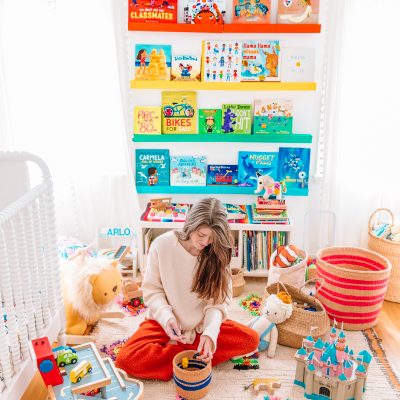 Someone sitting on the floor playing with toys
