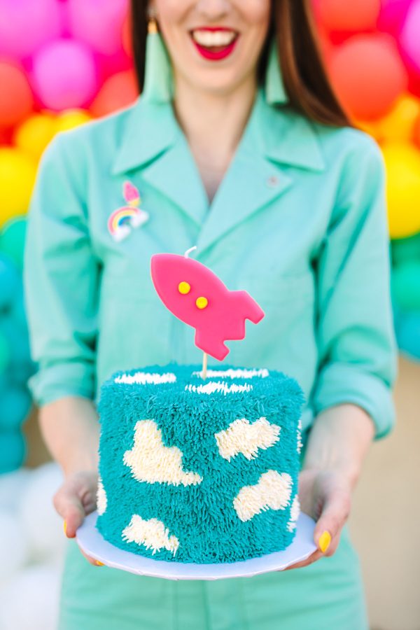 A girl in a blue shirt holding a cake