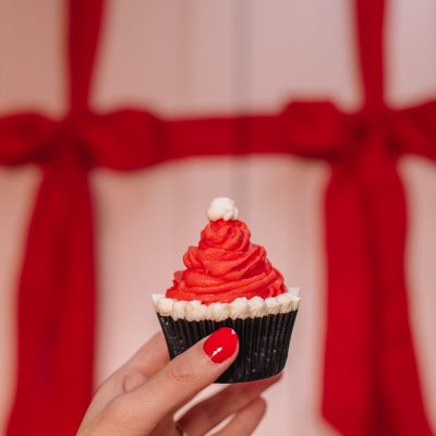 A person holding a Santa hat cupcake