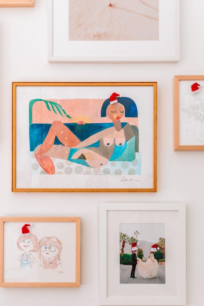 Photos on the wall with little Santa hats on their heads. 